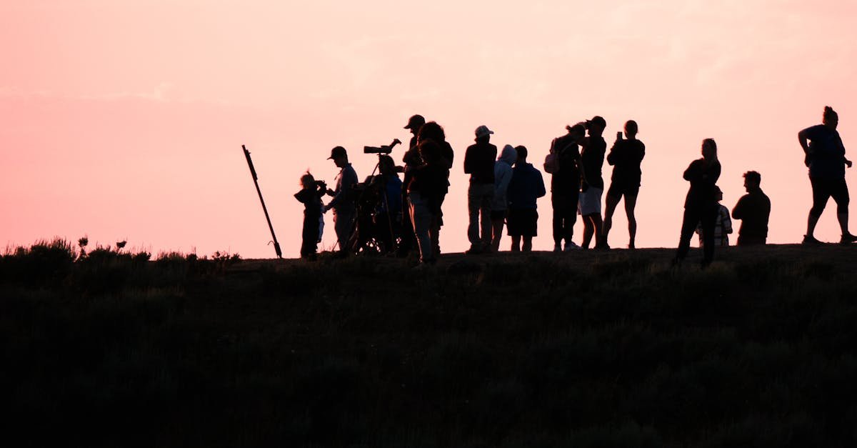 A group of people silhouetted against a vibrant sunset sky, capturing the beauty of twilight.